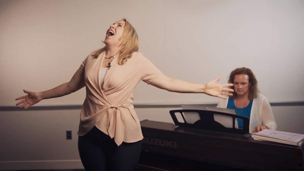 Docente mentre esegue il Belting durante una lezione di canto